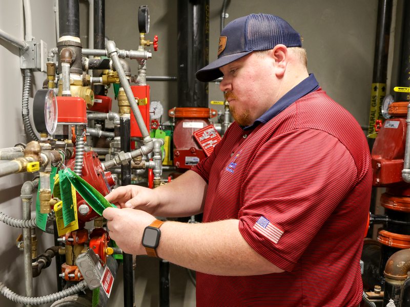Technician checking dated inspection tags