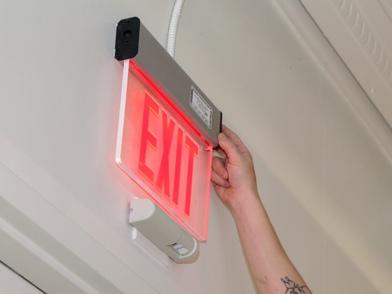 Hand adjusting the exit sign fixture
