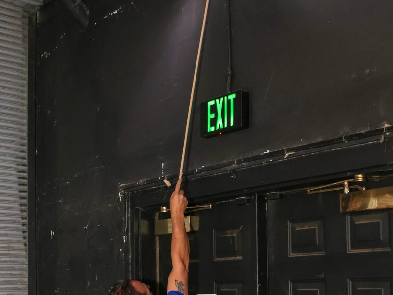 Technician testing emergency light and exit sign