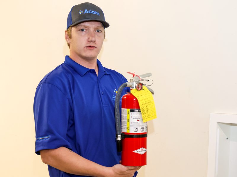 Technician holding a tagged extinguisher