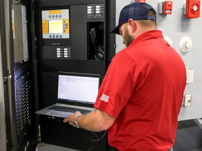 Technician programming the panel with a laptop