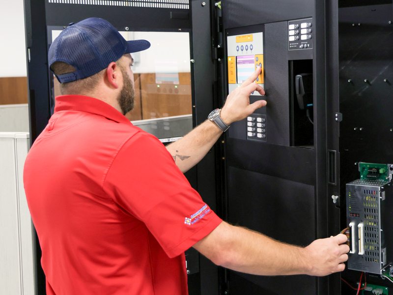 Technician operating a large fire alarm command panel