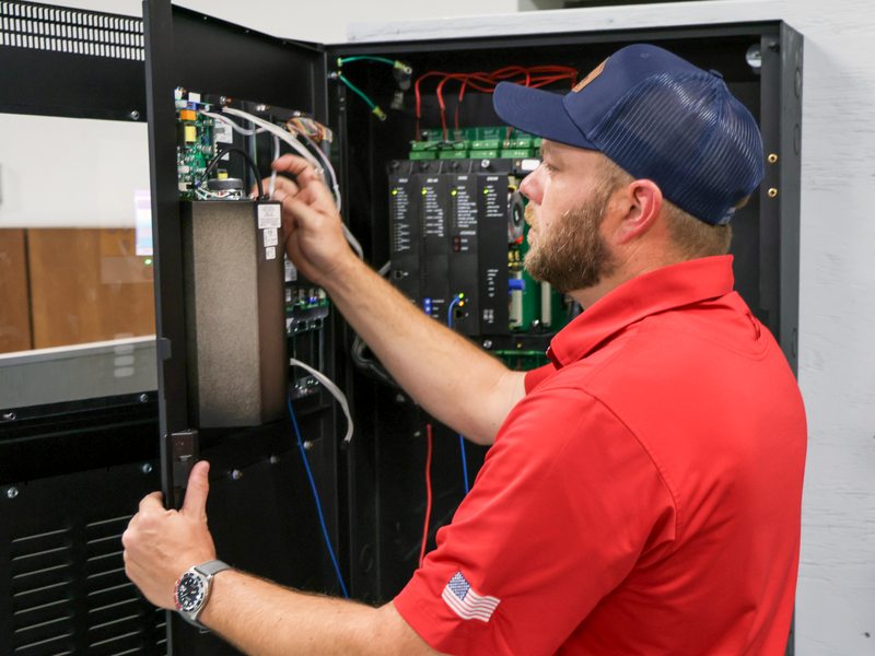 Technician servicing the alarm cabinet internals