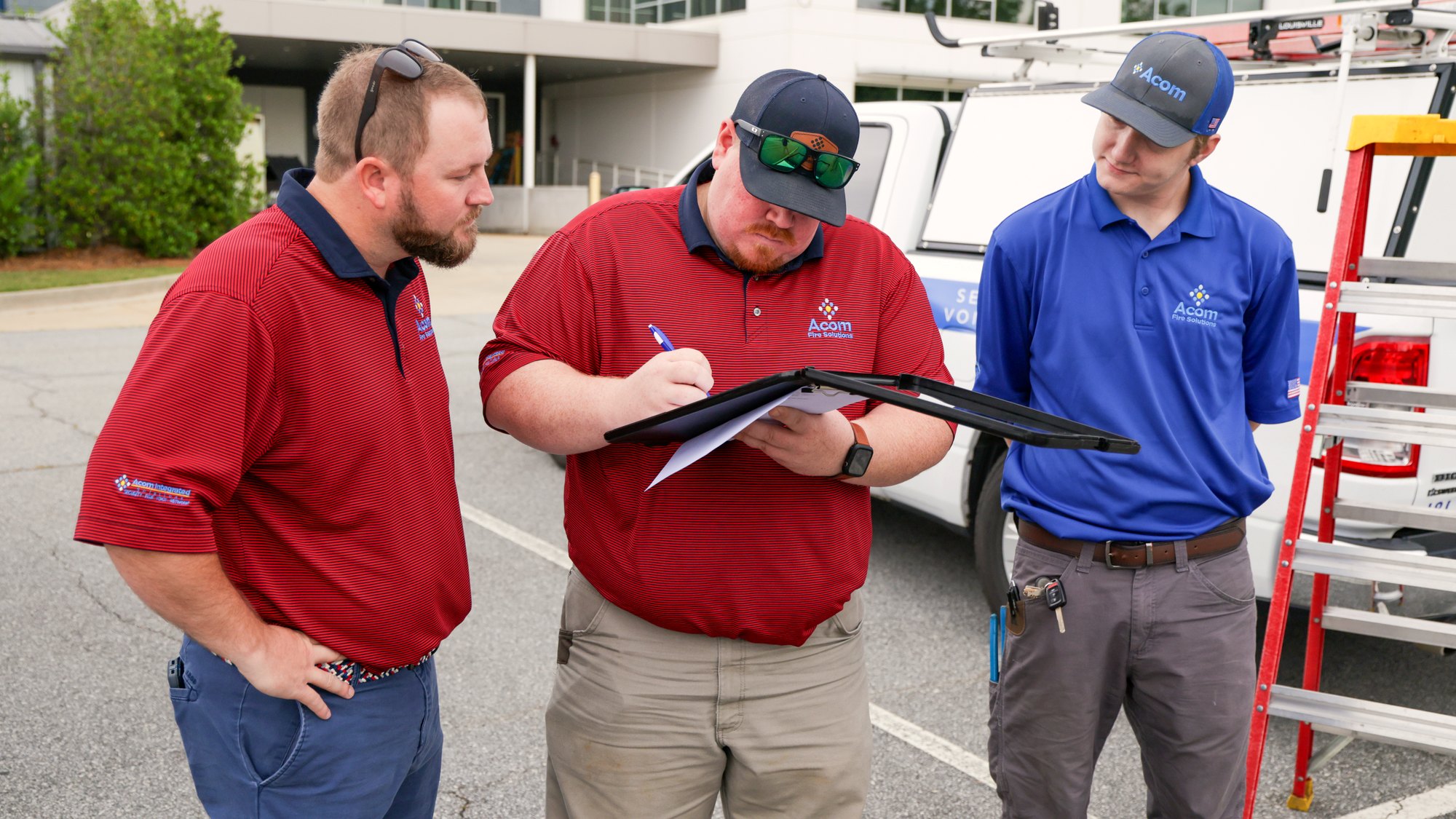 acom-hc-hero-team Acom technicians reviewing plans together at a customer site