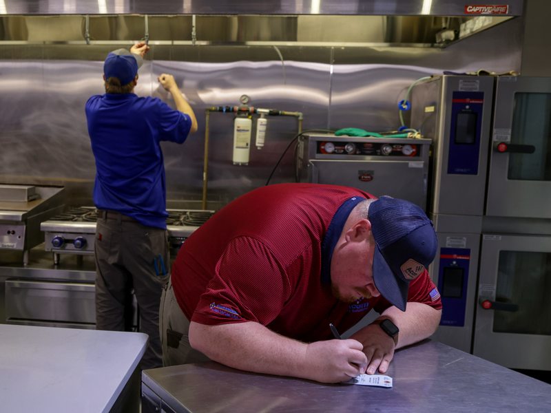 Technician writing the inspection tag during service