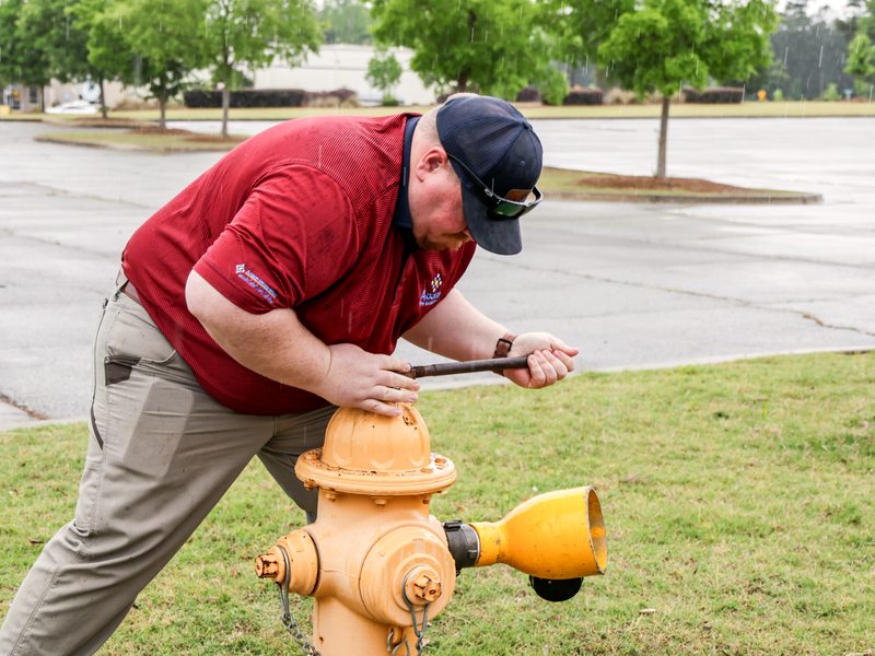 Technician operating the hydrant cap with a wrench