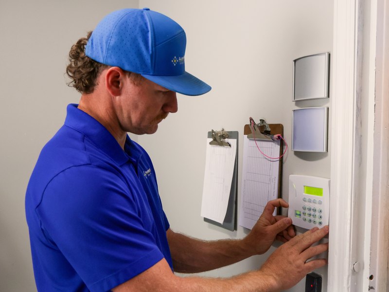 Acom technician at a commercial alarm keypad