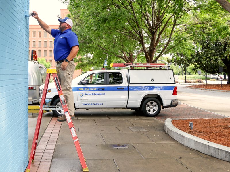 Acom technician installing an exterior perimeter camera
