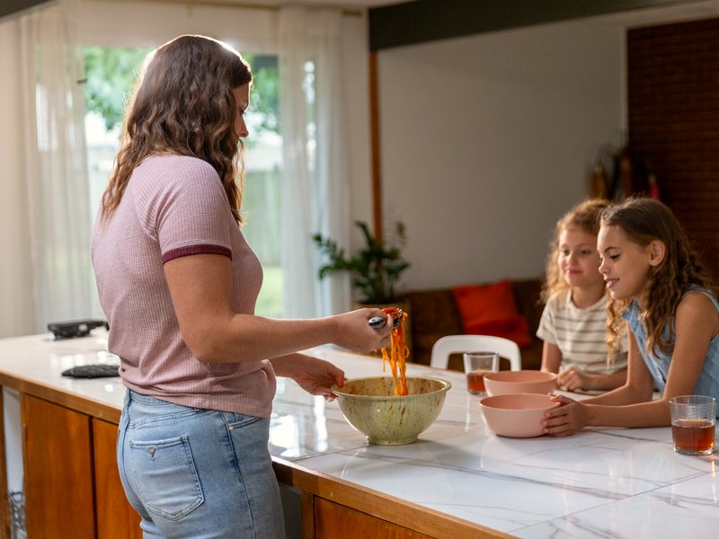 Family in the kitchen with a smart device
