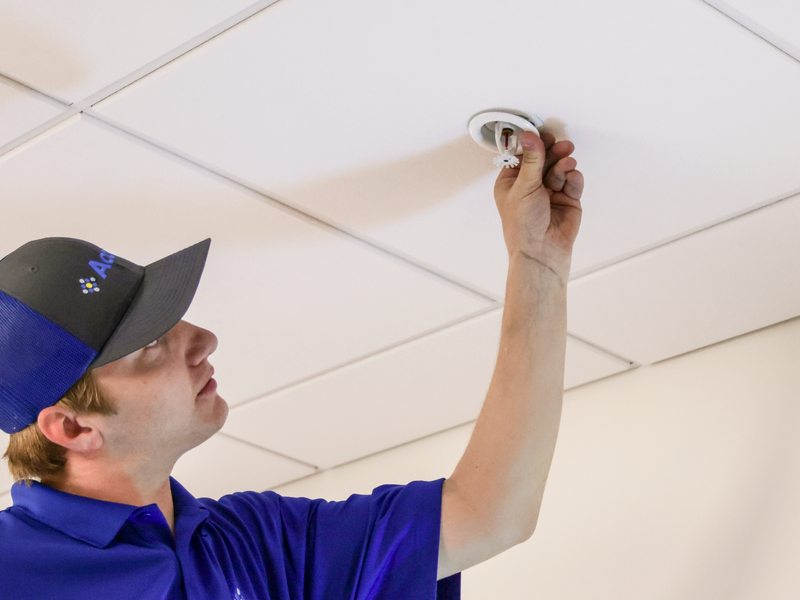 Technician inspecting a pendant sprinkler head