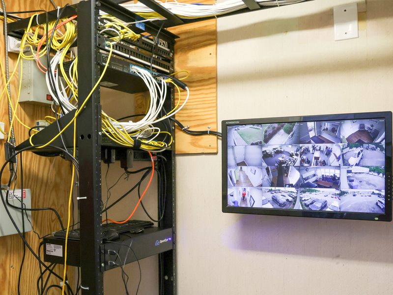 On-premises recording rack beside a surveillance monitor