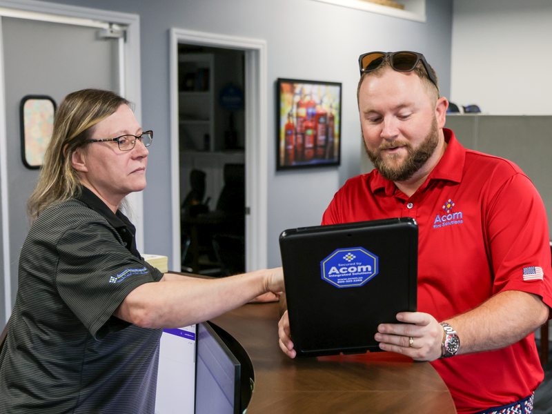 Two staff collaborating over a device