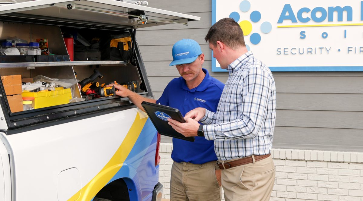 Acom technician and manager reviewing access on a tablet