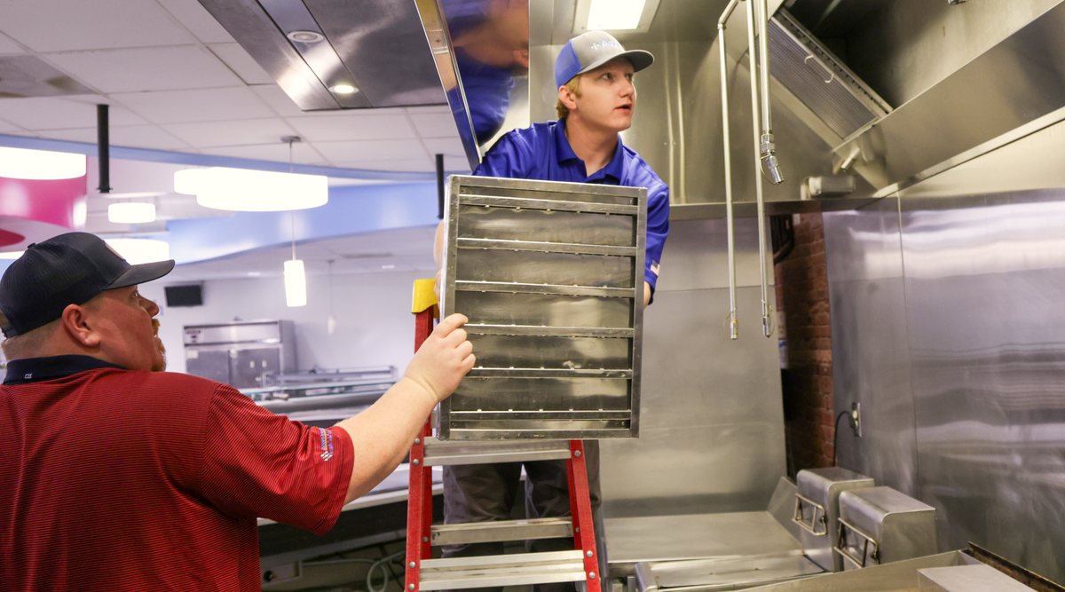 Acom technicians servicing the kitchen hood together