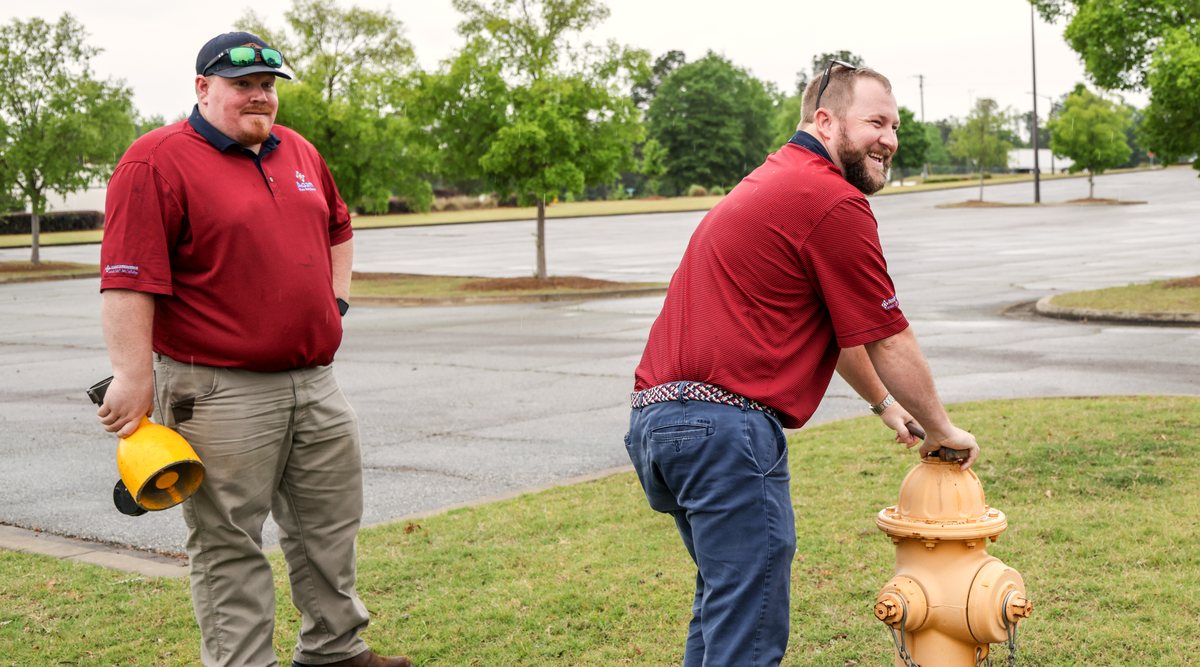 Dealership general manager reviewing a security system with an Acom technician