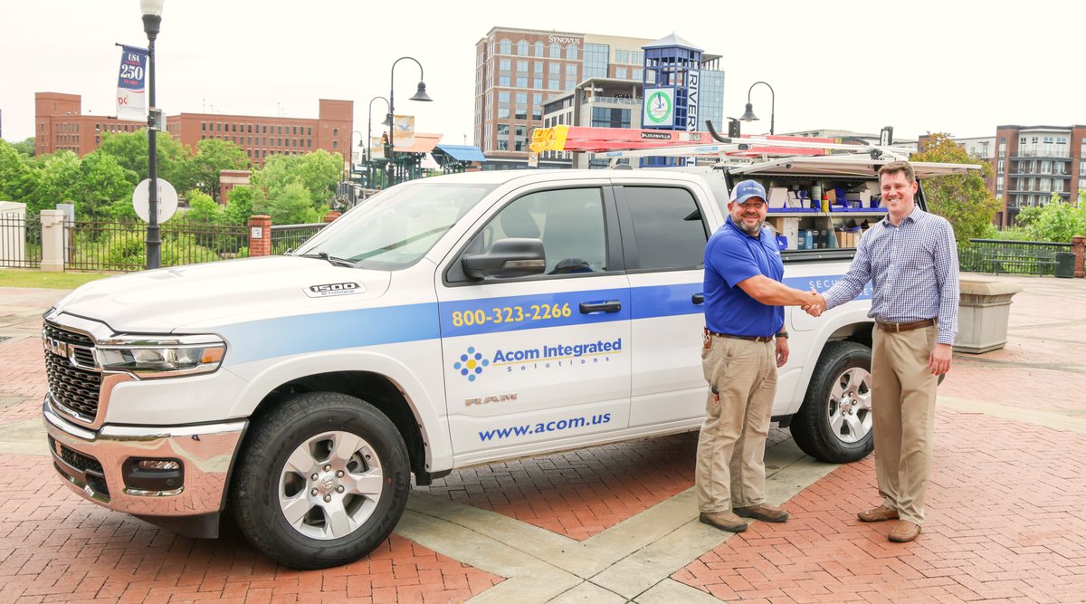 Handshake between Acom technician and customer beside the service truck
